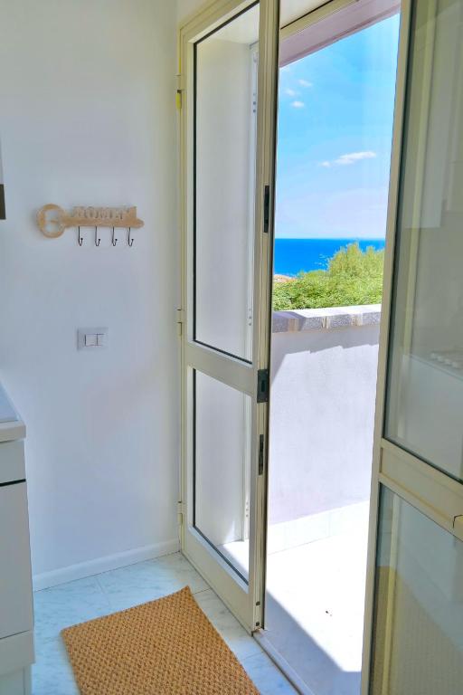 a door to a balcony with a view of the ocean at Villa Alba in Acitrezza