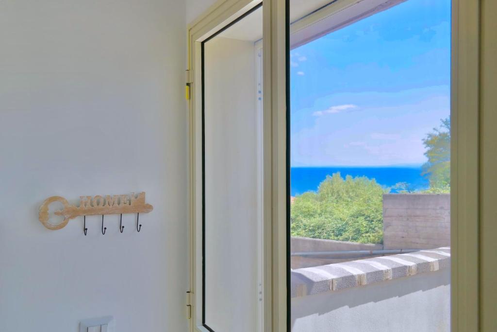 a sliding glass door with a view of the ocean at Villa Alba in Acitrezza