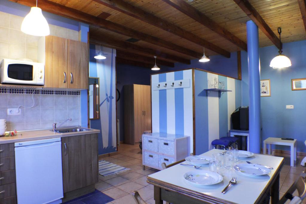 una cocina con 2 lavabos y nevera. en Apartamentos La Picota, en Cofiñal