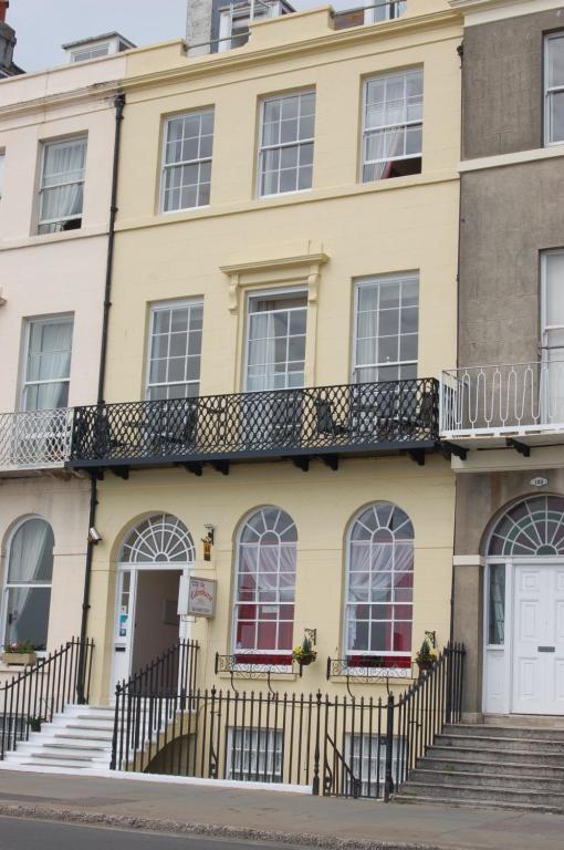 a yellow building with a balcony at The Edenhurst Guesthouse in Weymouth