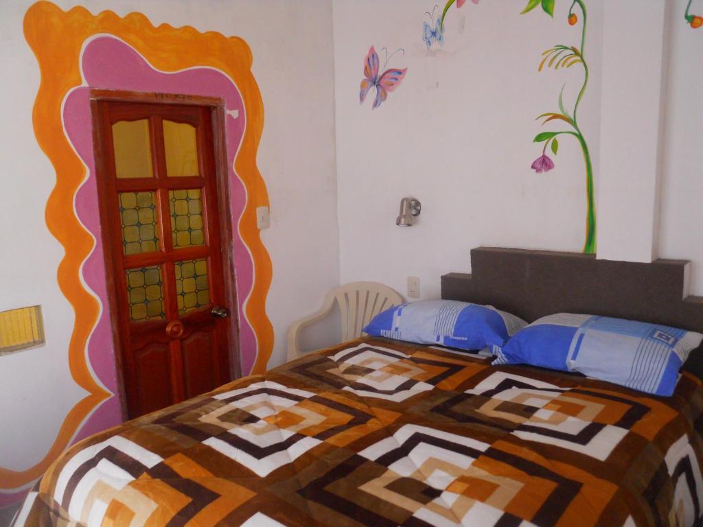 una camera da letto con un copriletto colorato di Hostal La Casa del Sol a Copacabana