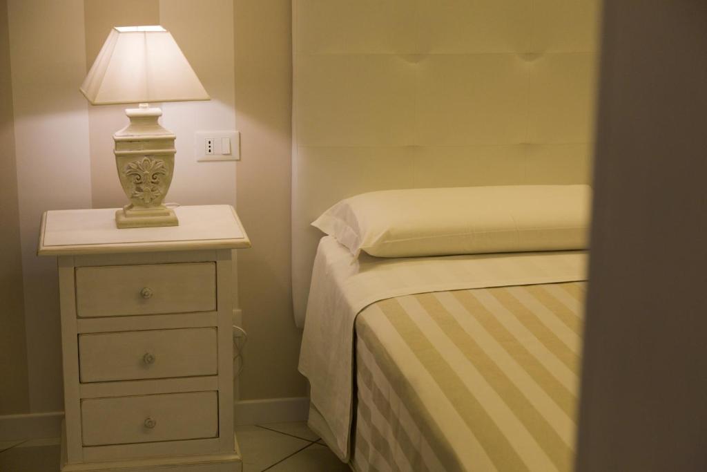 um quarto com uma cama e um candeeiro numa mesa de cabeceira em FalesiaConero em Sirolo
