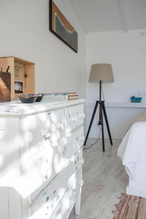 a white dresser in a bedroom with a lamp at O Moinho da Roca in Azoia
