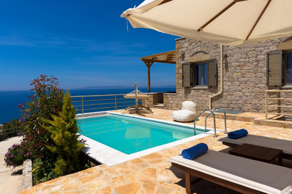 a villa with a swimming pool and the ocean at Tseralia Houses in Stoupa