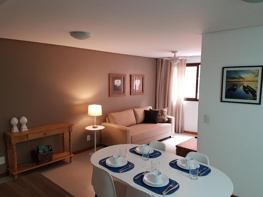 Maceio Facilities Apartamento Temporada في ماسيو: غرفة معيشة مع طاولة وأريكة