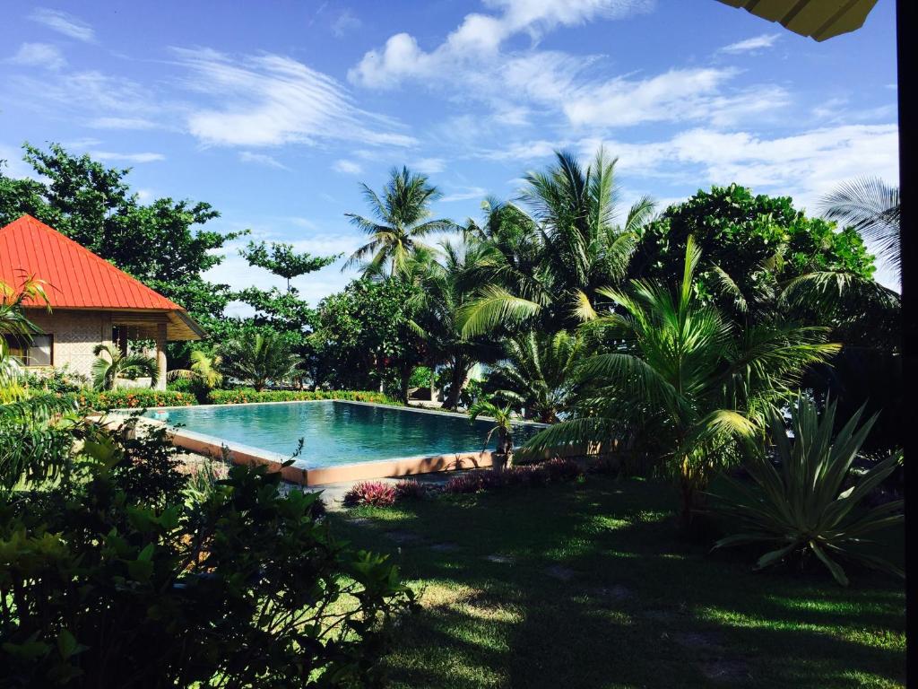 uma piscina num quintal com palmeiras em Pintuyan Dive Resort em Pintuyan