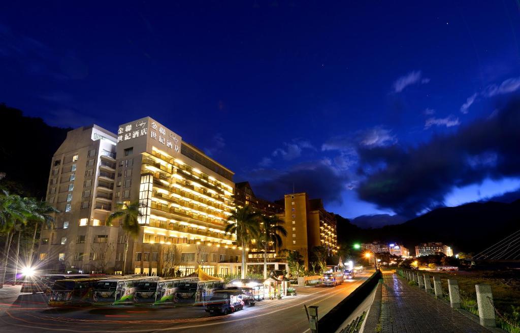 a city street at night with a building and buses at Chihpen Century Hotel in Wenquan