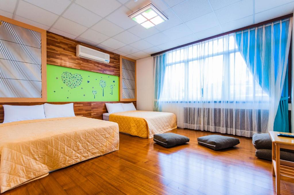a hotel room with two beds and a window at Kending Fengcai Homestay in Kenting