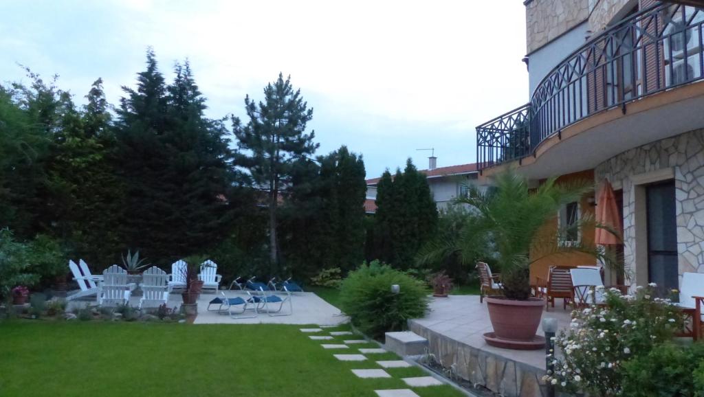 einen Garten mit Stühlen und Tischen und ein Gebäude in der Unterkunft Toscana Lakeside Apartments I - II Family friend in Siófok