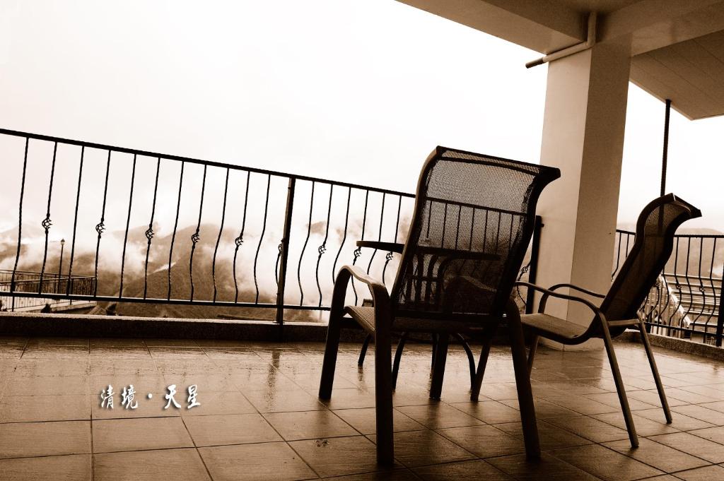 two chairs sitting on a balcony looking at the ocean at Star Villa in Ren&#39;ai