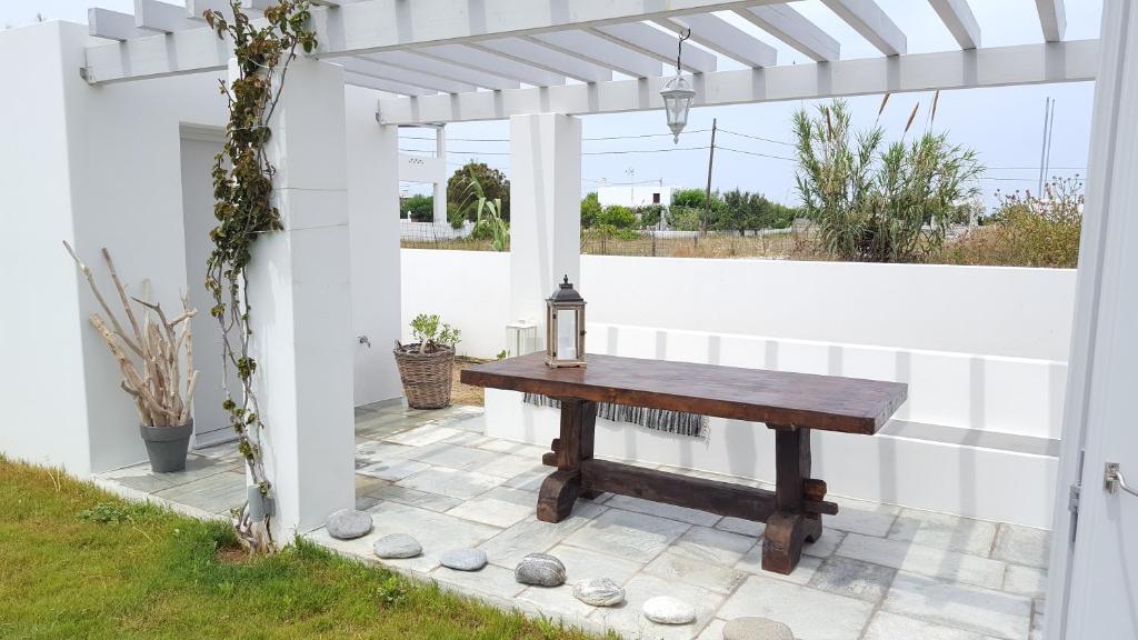 スキロスにあるAkrotiri Skyrosの白いパーゴラの下のパティオに座る木製テーブル