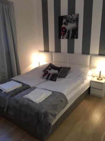 a bedroom with a large bed with two lamps on it at Morski Relax in Gdynia