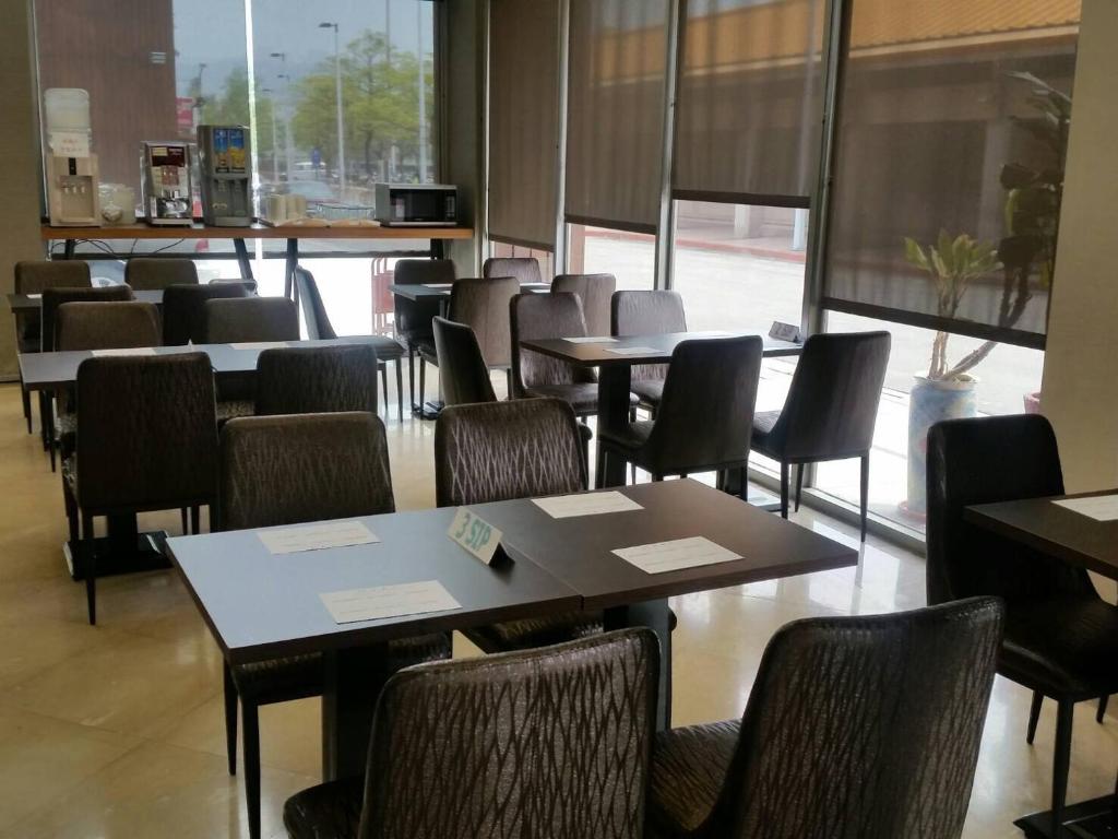 a dining room with tables and chairs and a large window at Hotel Leisure Beitou in Taipei