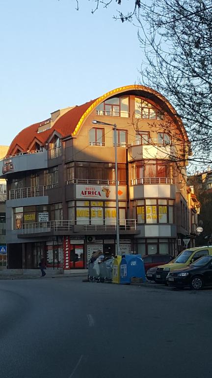 un gran edificio con coches estacionados frente a él en Hotel Africa, en Haskovo