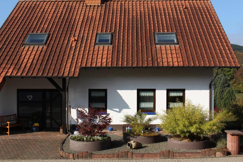 una casa con techo rojo y algunas plantas en Ferienwohnung Zoe, en Osterbrücken