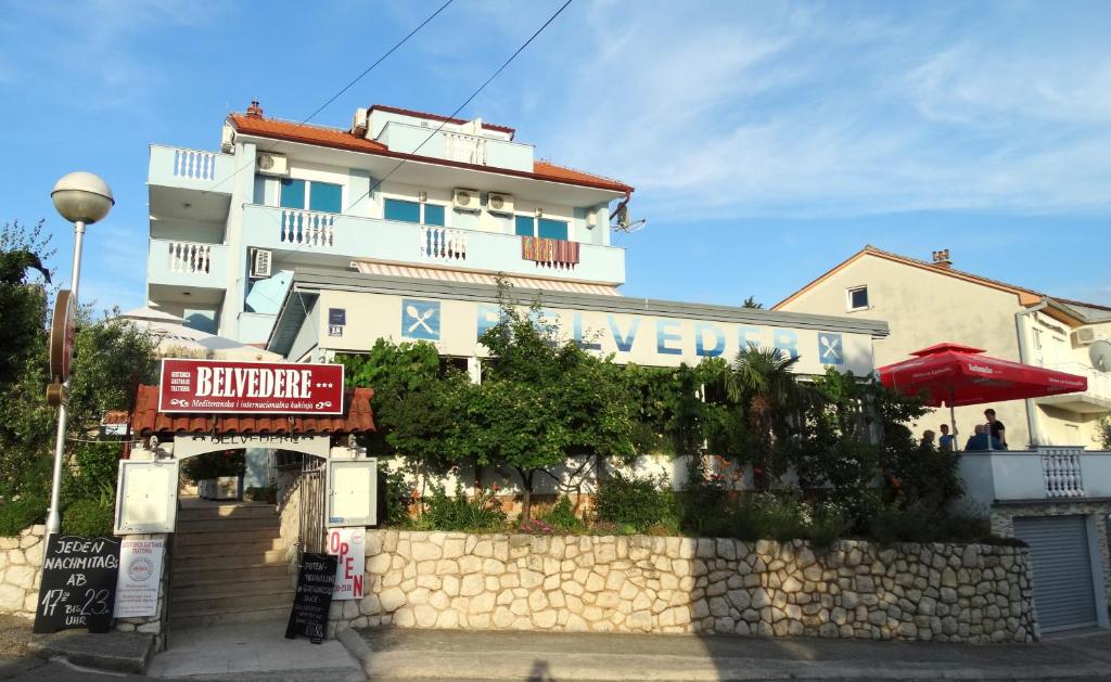 a white building with a sign in front of it at Pansion Belveder in Crikvenica