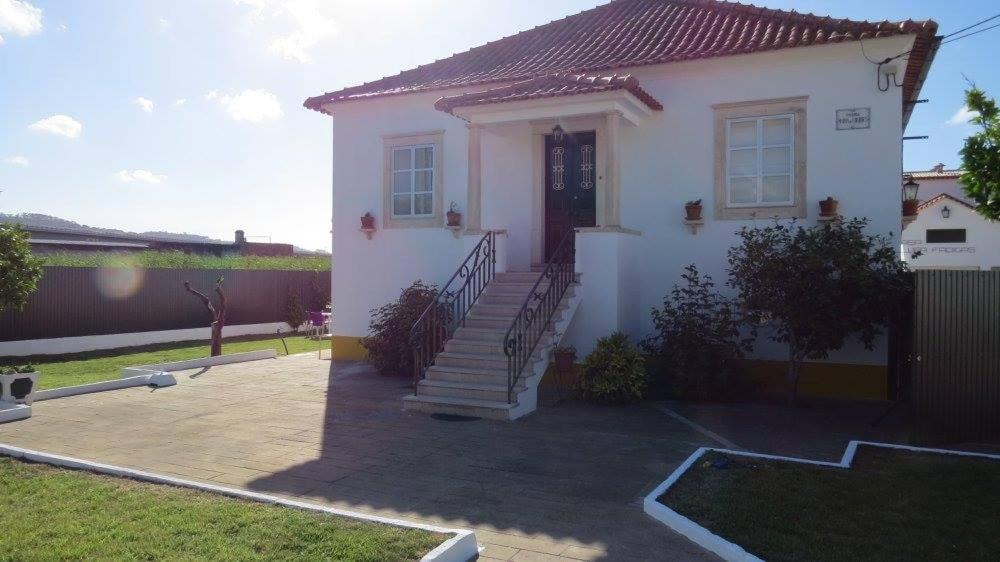 a white house with a staircase in a yard at Vivenda Maria de Lourdes in Maiorga