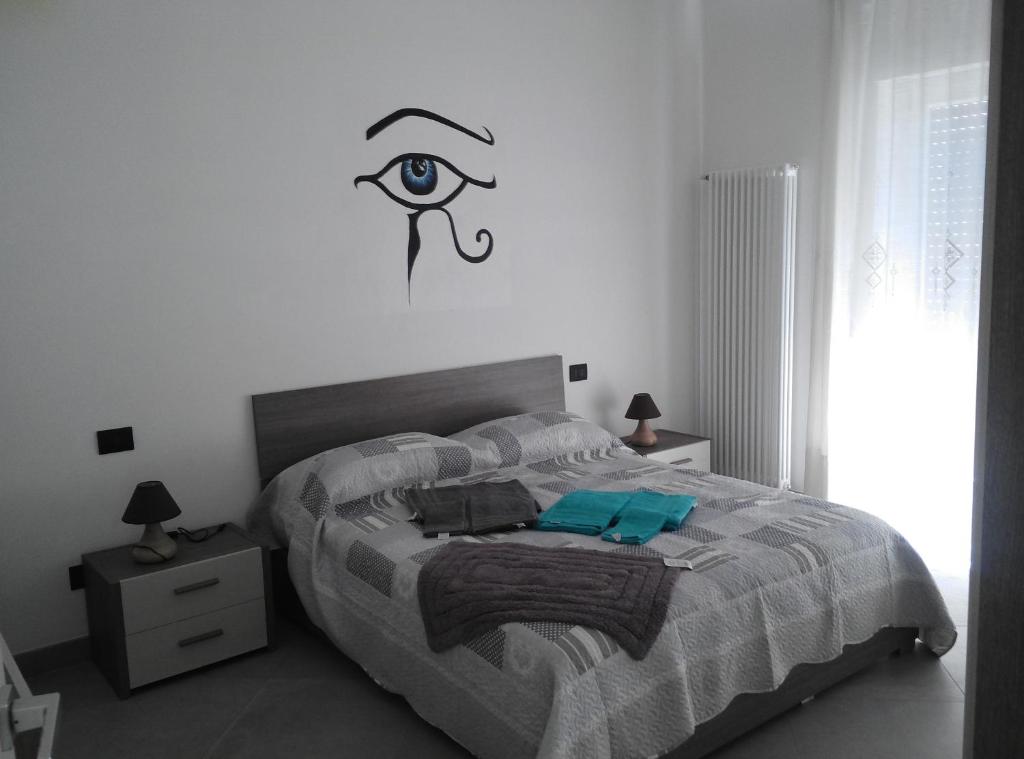 a bedroom with a bed with an eye on the wall at Affittacamere Di Paola in Lugagnano