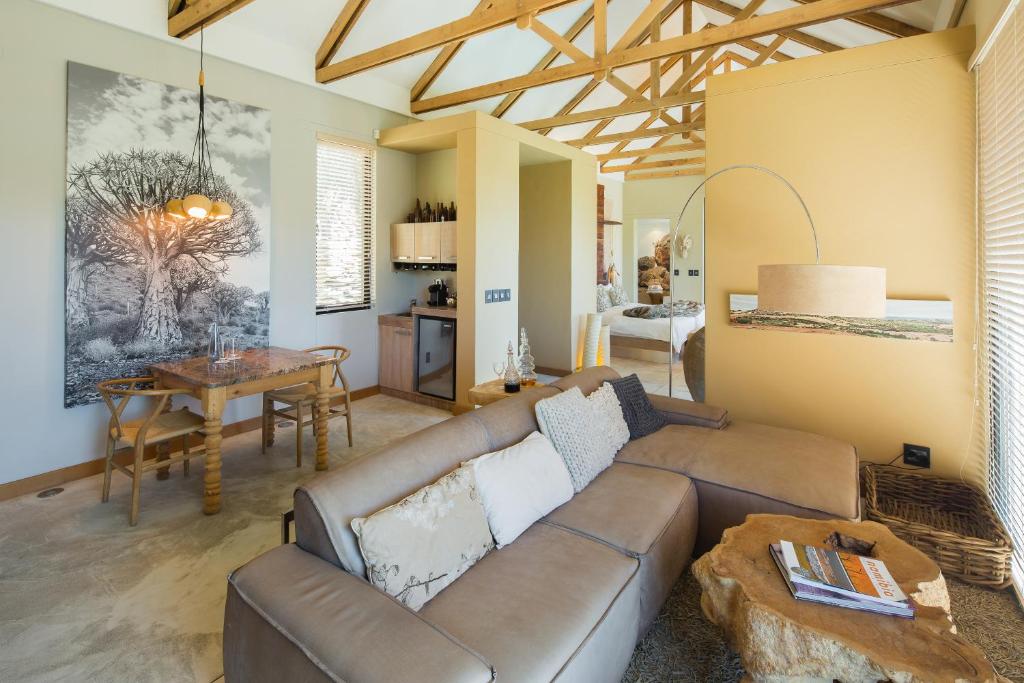 uma sala de estar com um sofá e uma mesa em The Olive Exclusive All-Suite Hotel em Windhoek