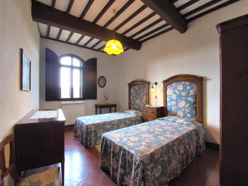 una camera d'albergo con due letti e una finestra di Castello di Montalto a Castelnuovo Berardenga