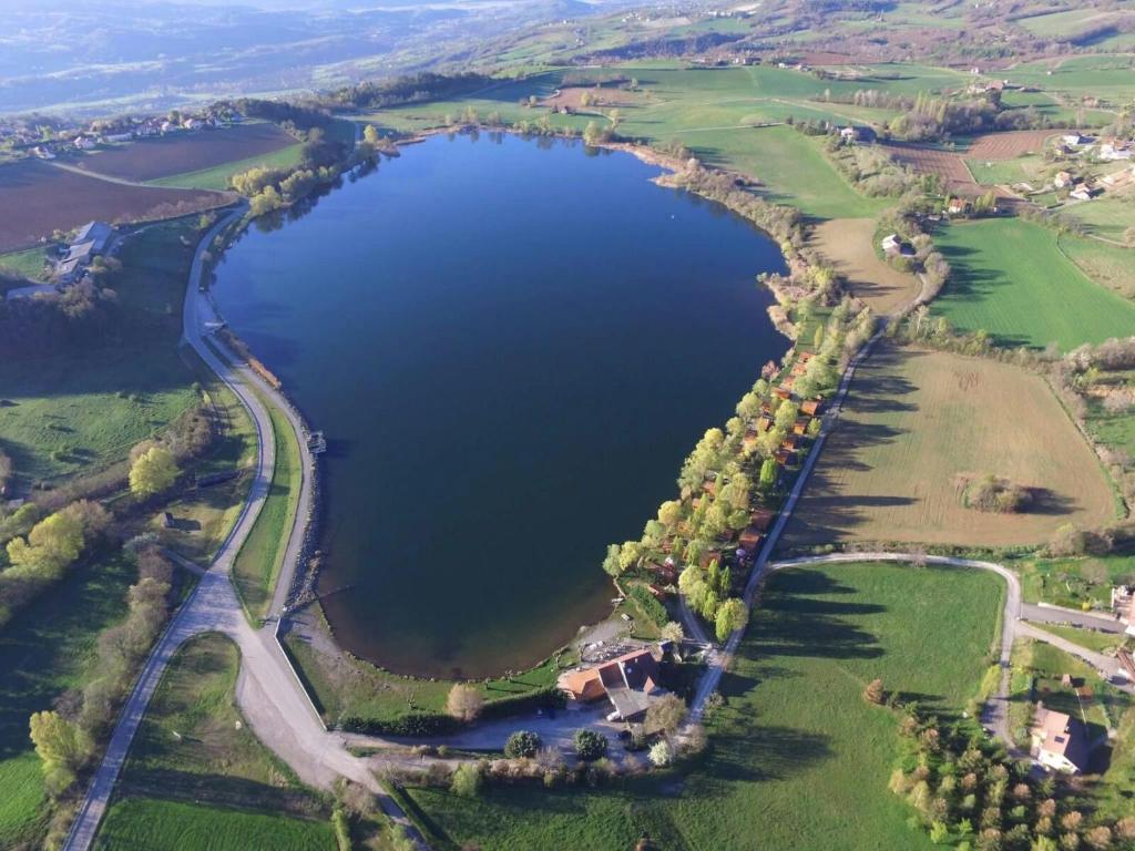 an aerial view of a lake with trees and a road at Camping La Motte Flottante in La Freissinouse