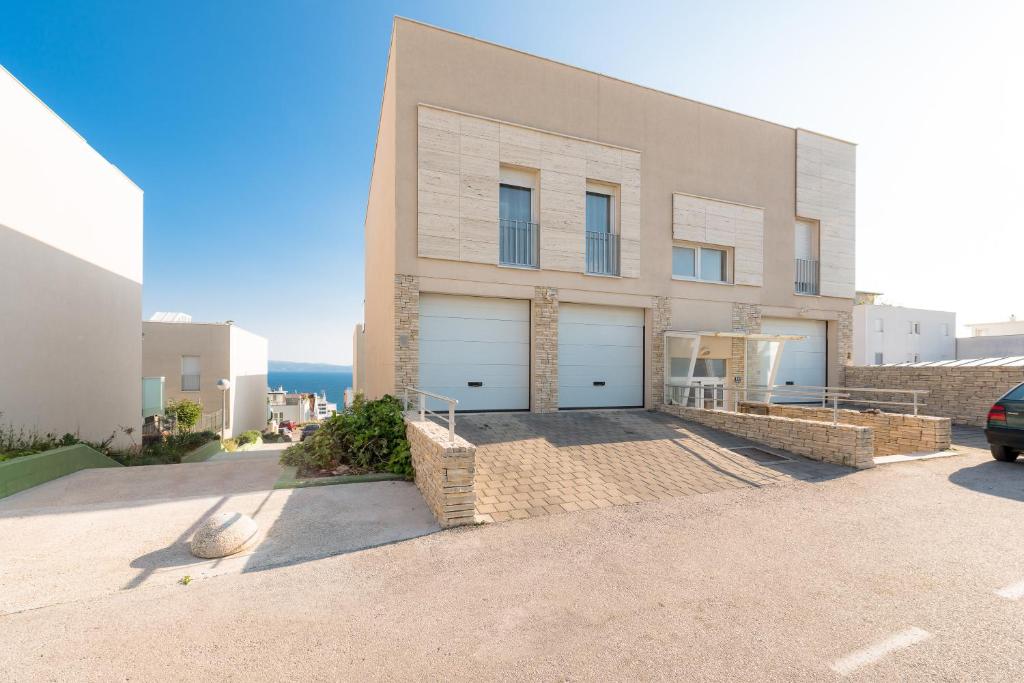 Comfort LUXE Adriatic View & JACUZZI Znjan BEACH في سبليت: منزل كبير مع بابين جراج في شارع