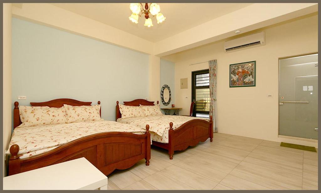 花蓮市的住宿－喬治花園民宿，一间卧室配有两张床和吊灯。