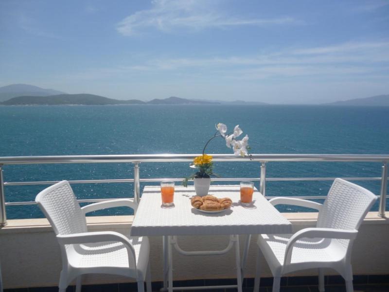 einen Tisch und Stühle auf einem Balkon mit Meerblick in der Unterkunft Beautifull Holiday Apartment Larisa in Sarandë