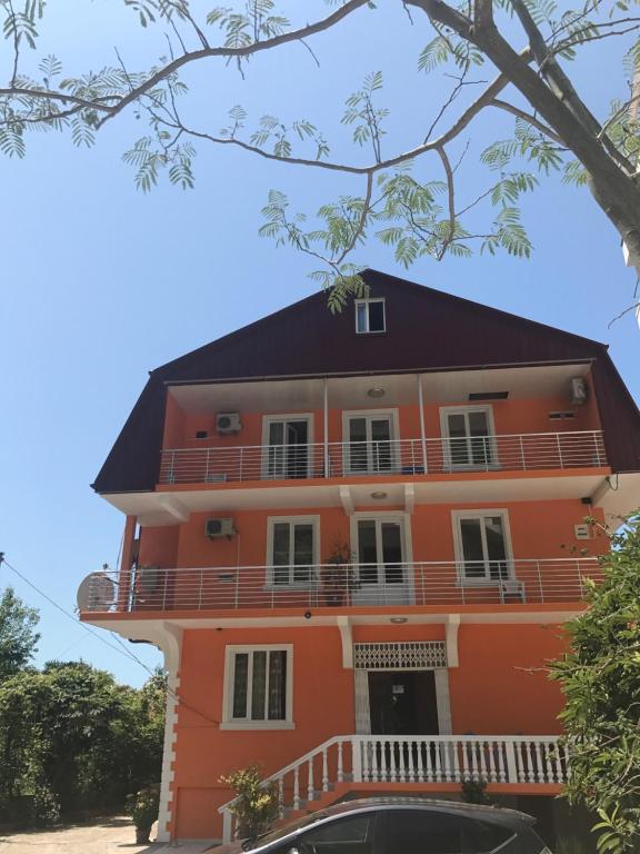 pomarańczowy dom z czarnym dachem w obiekcie Kvariati - Guest House w mieście Kvariati
