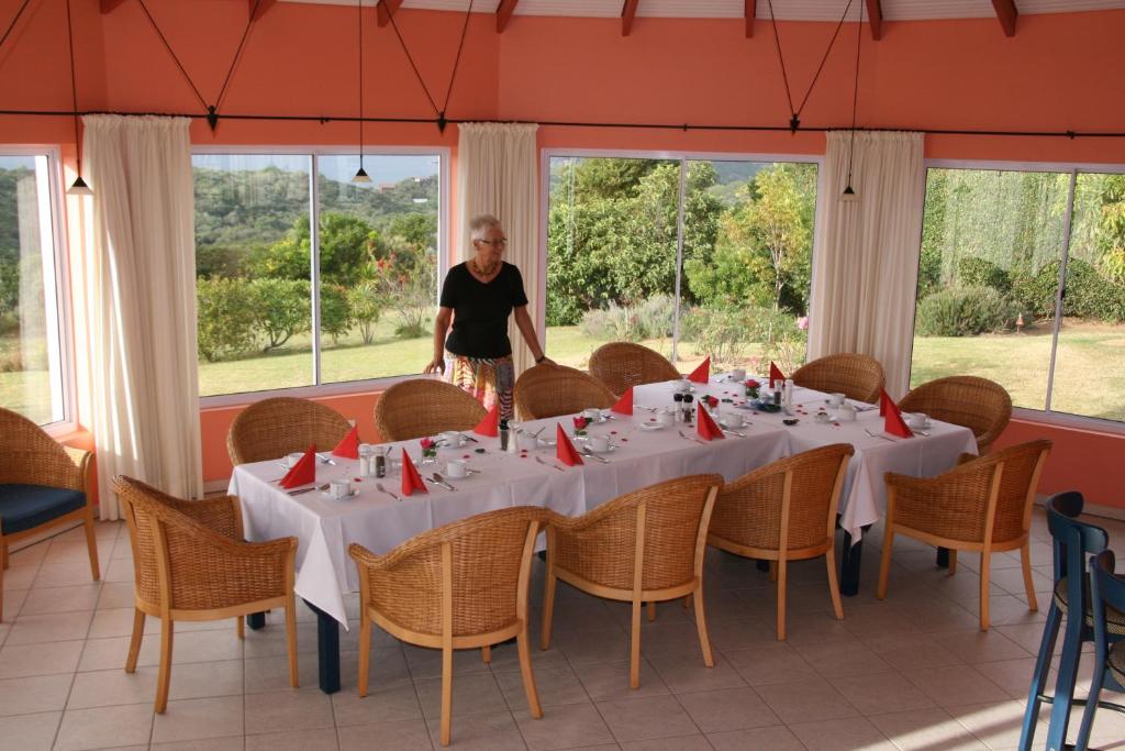 Un uomo in piedi davanti a un tavolo con tovaglioli rossi di Cintsa Lodge a Chintsa