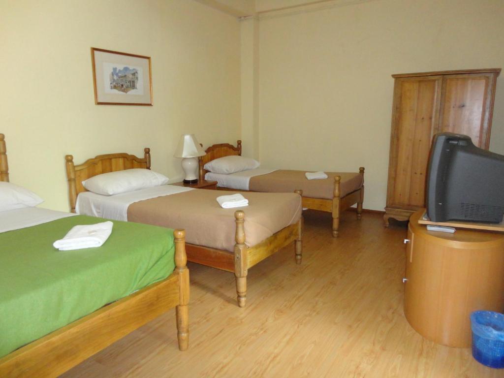 Cette chambre comprend 2 lits et une télévision à écran plat. dans l'établissement Pristine Hotel, à Rawang