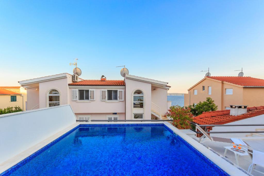 eine Villa mit einem Pool und einem Haus in der Unterkunft Apartments Meri in Trogir