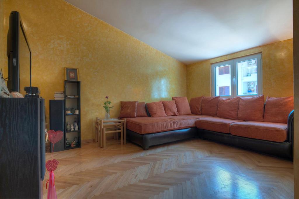 - un salon avec un canapé brun et une fenêtre dans l'établissement Apartment Mira, à Budva