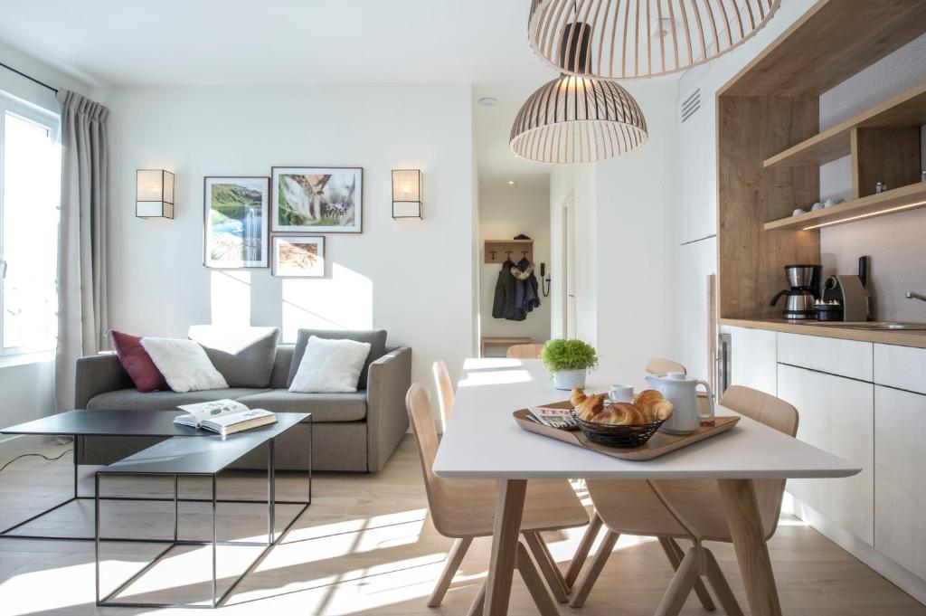a kitchen and living room with a table and chairs at Le Génépy - Appart'hôtel de Charme in Chamonix