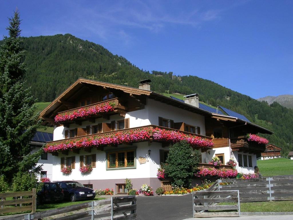 un edificio con flores a un lado. en Haus Bergheimat, en Kals am Großglockner