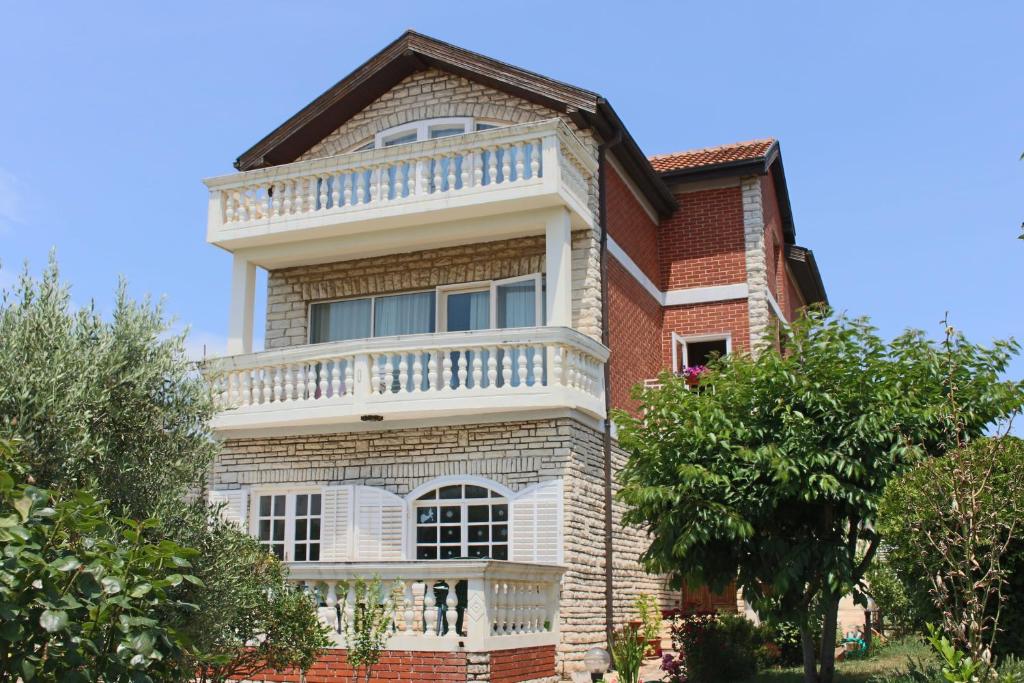 una grande casa in mattoni con balcone bianco di Apartments Guberina a Šibenik
