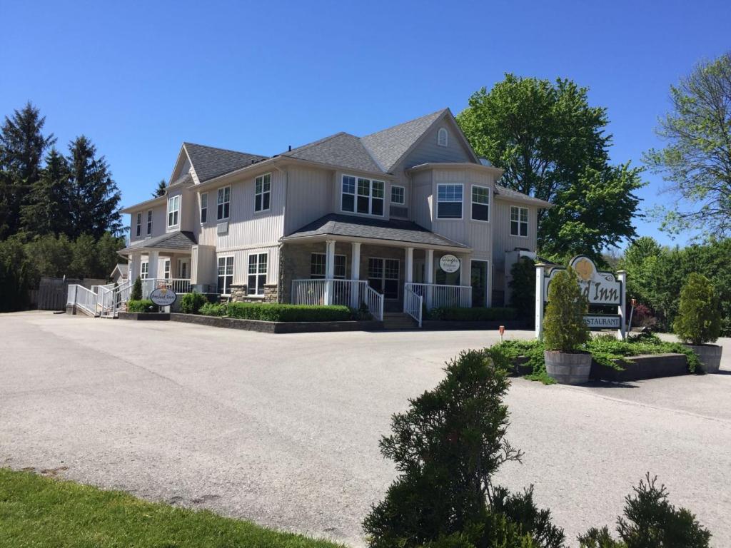 uma grande casa branca com uma grande entrada em Orchid Inn em Niagara on the Lake