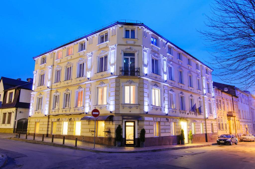 un grand bâtiment blanc sur le côté d'une rue dans l'établissement Hotel Irena, à Lviv