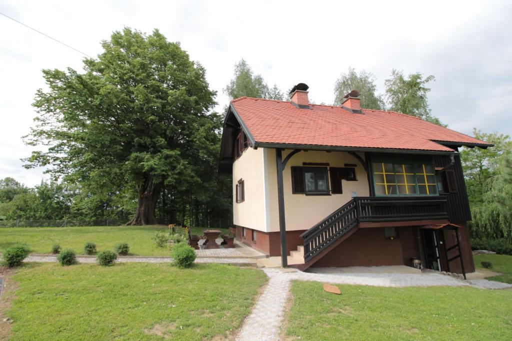 una piccola casa con un tetto rosso in un campo di Holiday Home Winzerhaus Eva a Špičnik