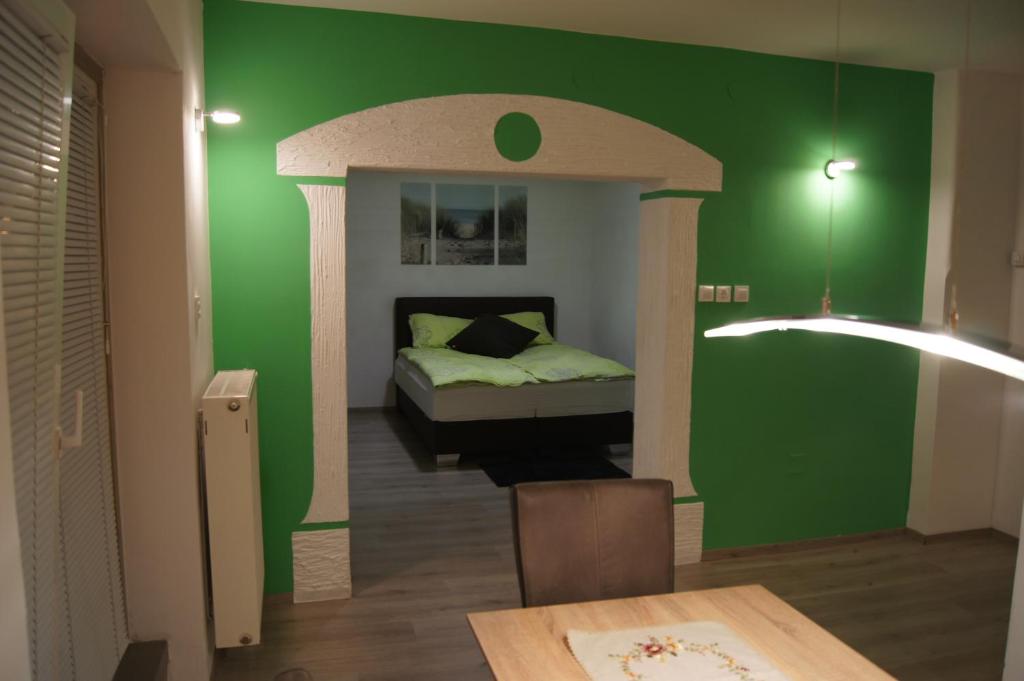 um quarto com uma parede verde e uma cama em Domas RD Apartment em Ljubljana