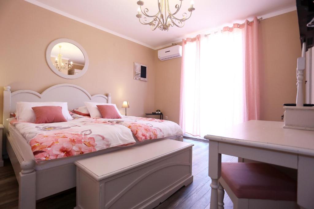 sypialnia z łóżkiem, stołem i oknem w obiekcie Shabby chic rooms w mieście Zadar