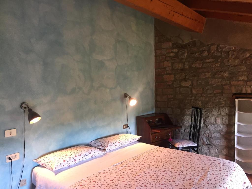 a bedroom with a bed with two lights on the wall at Agriturismo Spizzirò in Ponte Nizza
