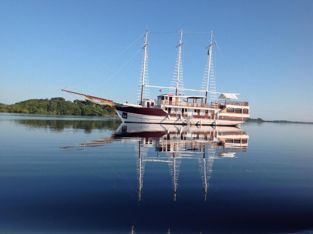 um barco sentado na água com o seu reflexo em MV Desafio em Manaus