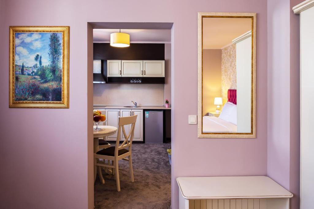 eine Küche und ein Esszimmer mit einem Tisch und einem Spiegel in der Unterkunft Villa Antica in Plowdiw