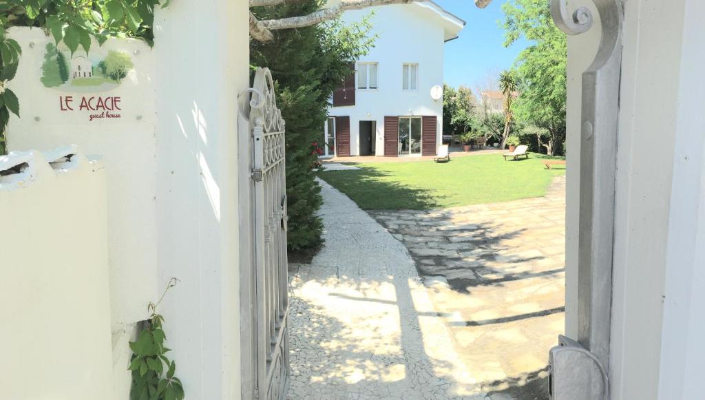 a white house with a gate and a yard at Guest House Le Acacie in Spoltore