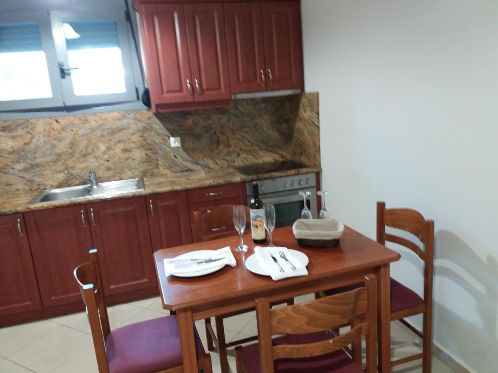 アルゴストリオンにあるSpyros Apartmentsのキッチン(木製テーブル、椅子、シンク付)