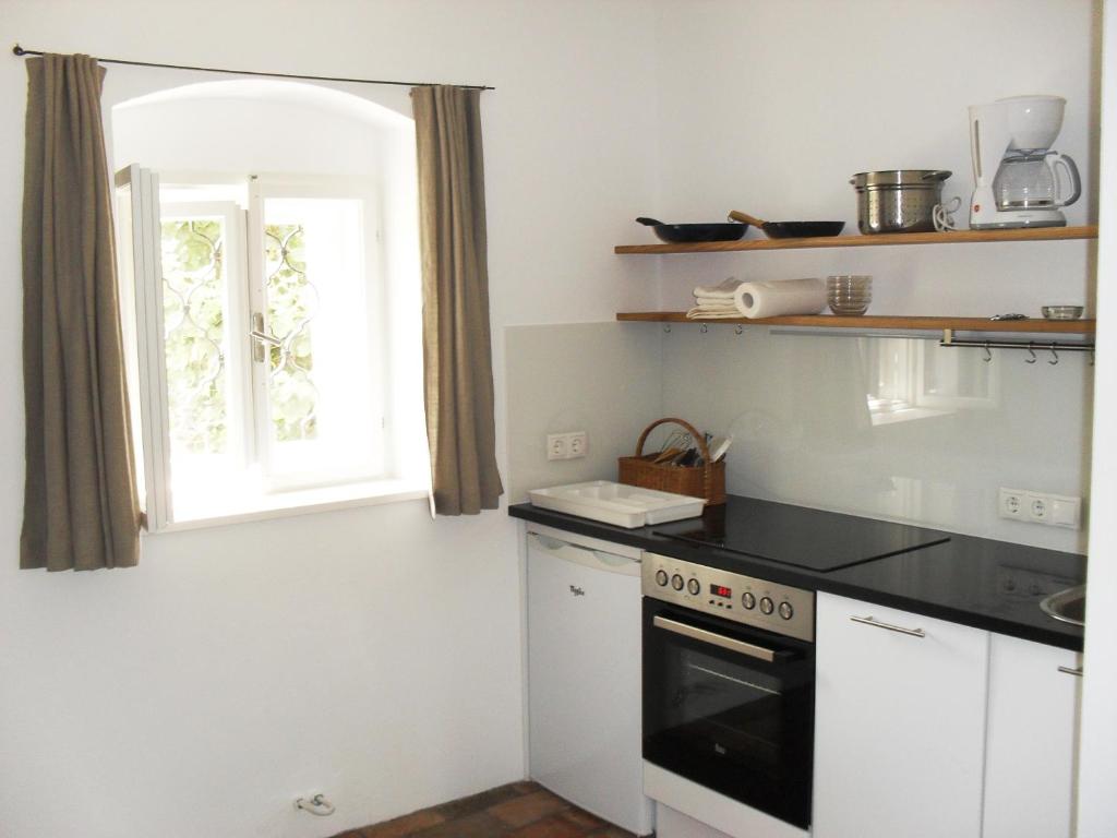 a kitchen with a stove and a window at Alte Mühle Kaisersdorf in Kaisersdorf