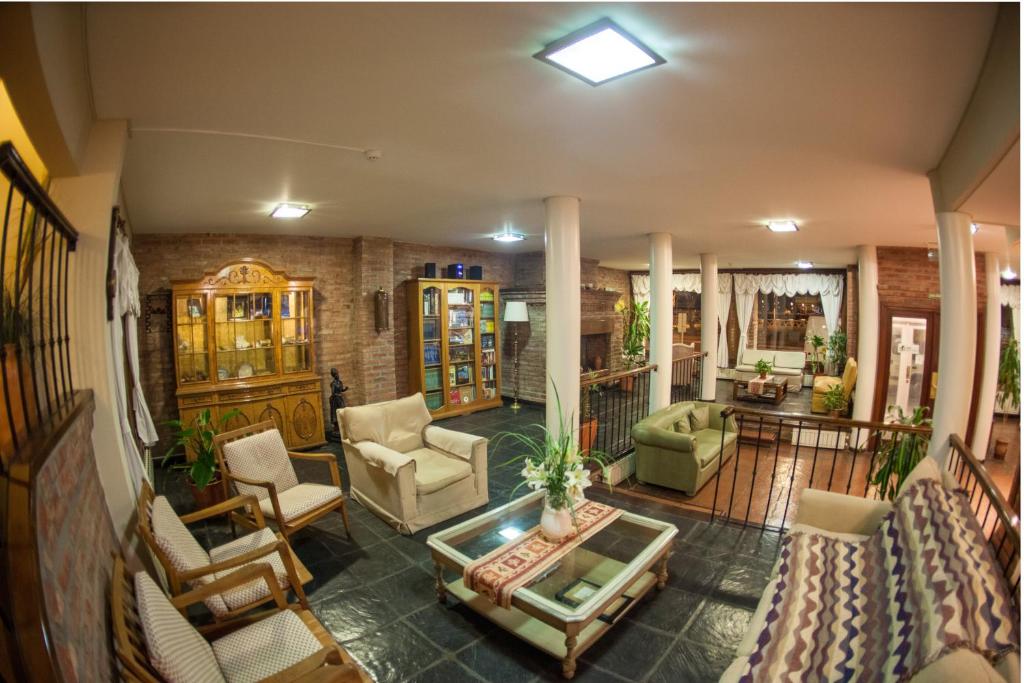 a living room with chairs and a table at Hotel Bahia Nueva in Puerto Madryn