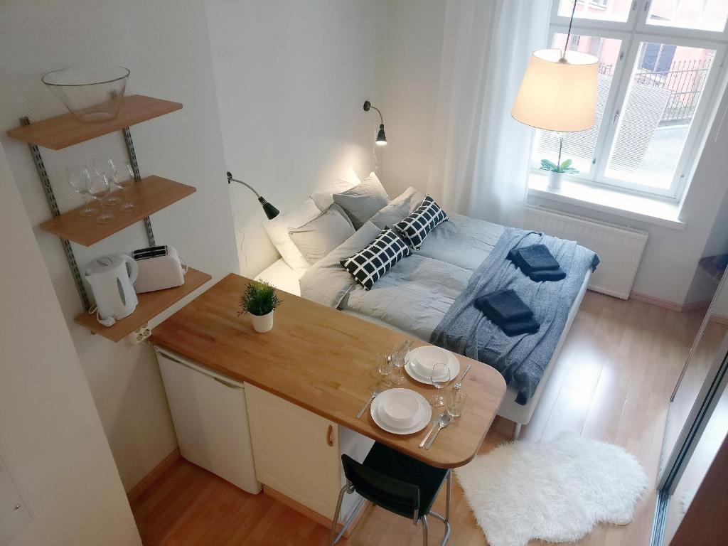 a small room with a bed and a desk with a table sidx sidx at 2ndhomes Kamppi Apartments 2 in Helsinki