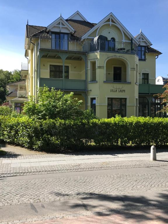 a yellow building with a balcony on top of it at Villa Laura in Kühlungsborn